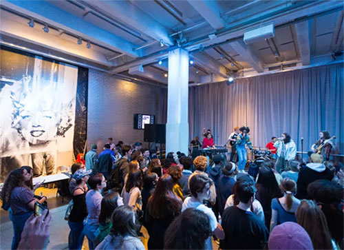 Teens watching a band play at the Warhol museum